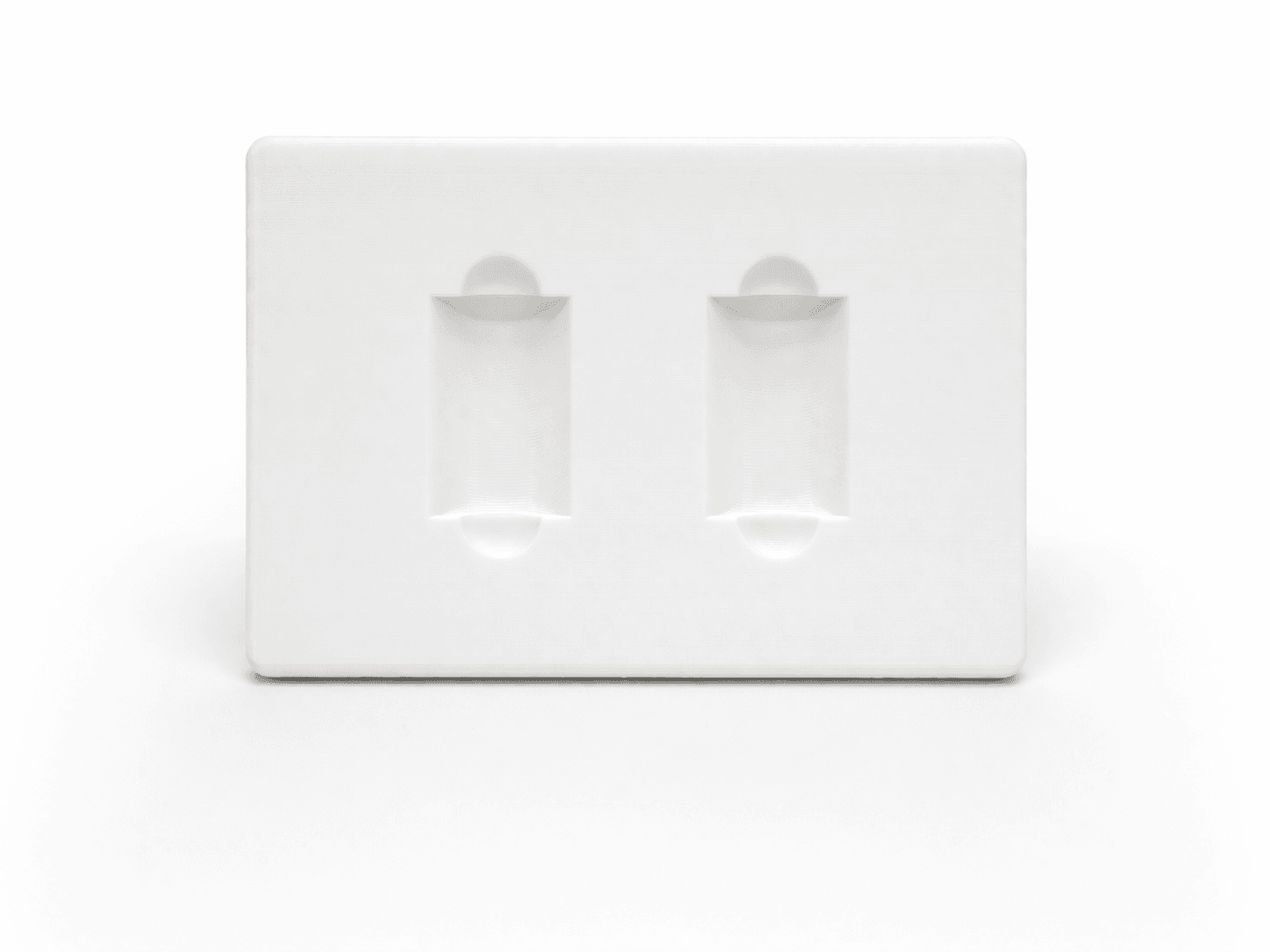 White 3D printed alignment fixture with two pocketed cavities, precisely sized to hold parts for assembly or inspection